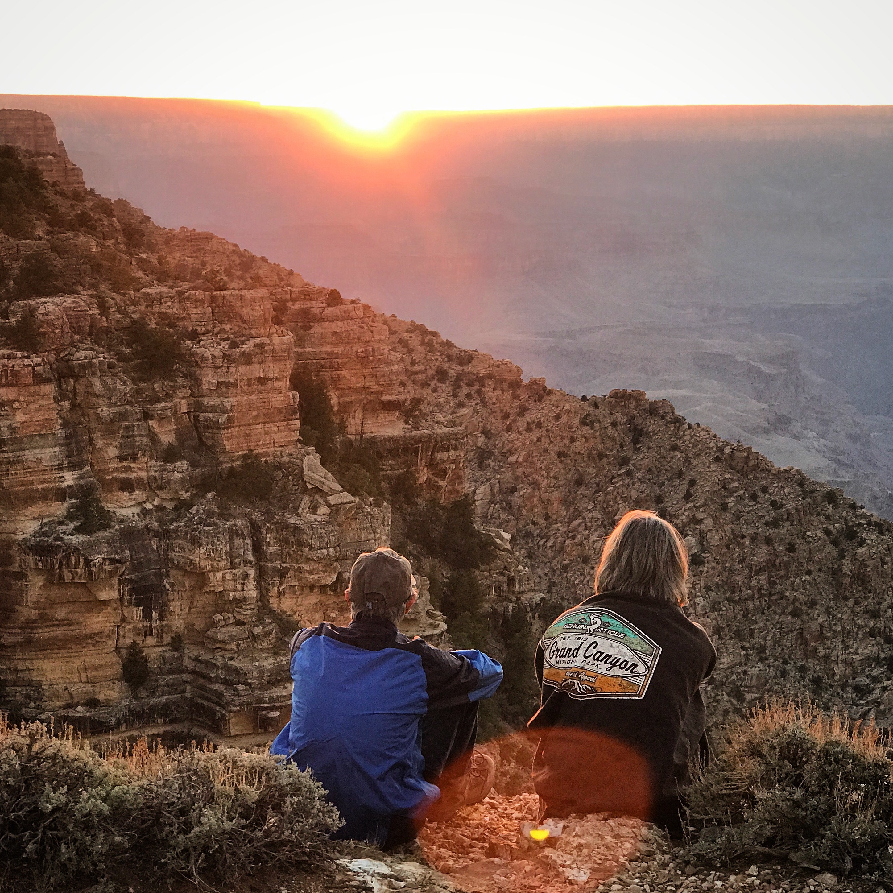 Two guests overlooking the Grand Canyon during a sunset rim tour