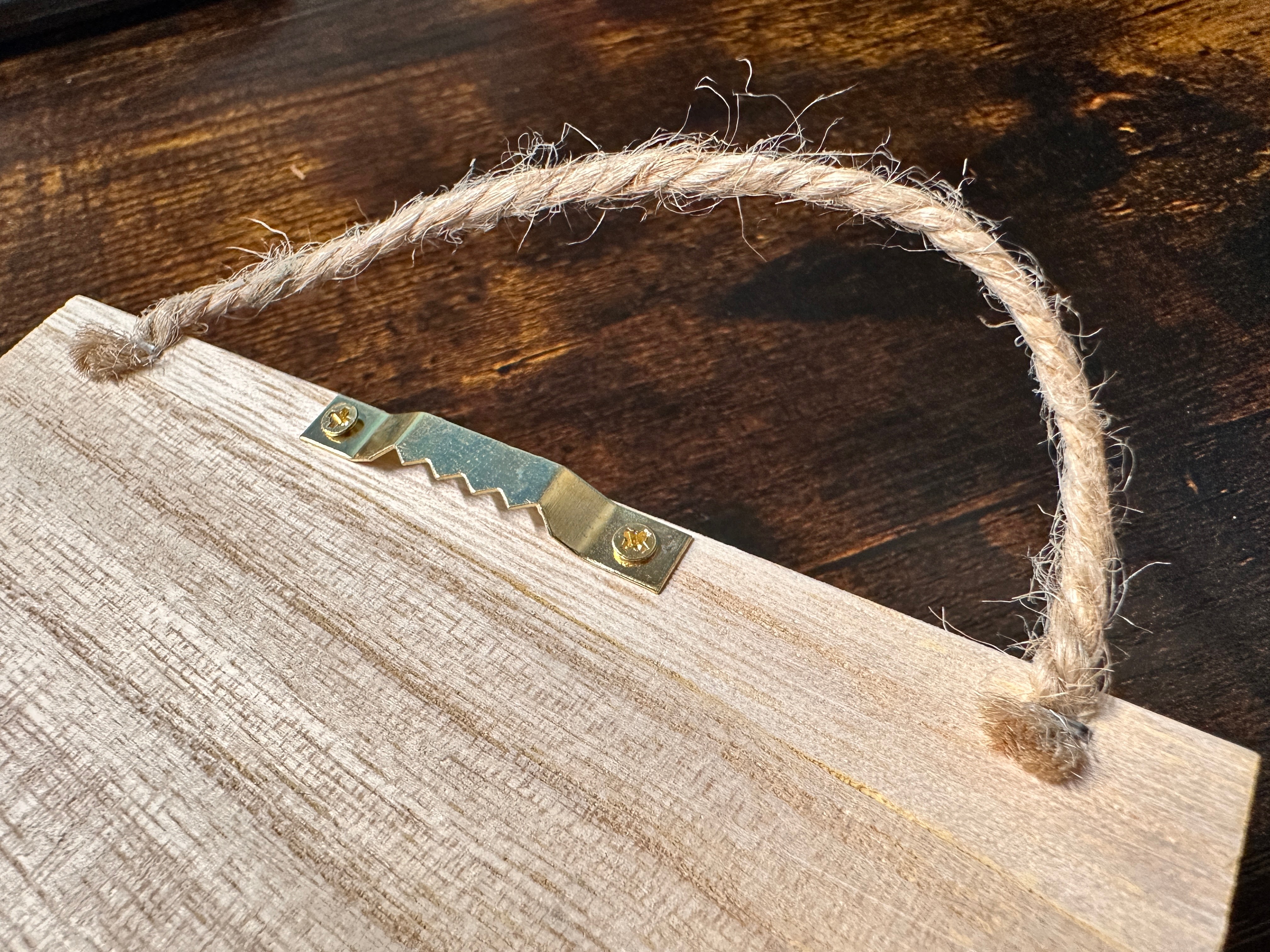 Canyon Ministries Grand Canyon 3D Model Close-up of the back of a wooden sign with a sawtooth hanger, two screws, and rough twine loops for hanging; rustic wood finish.