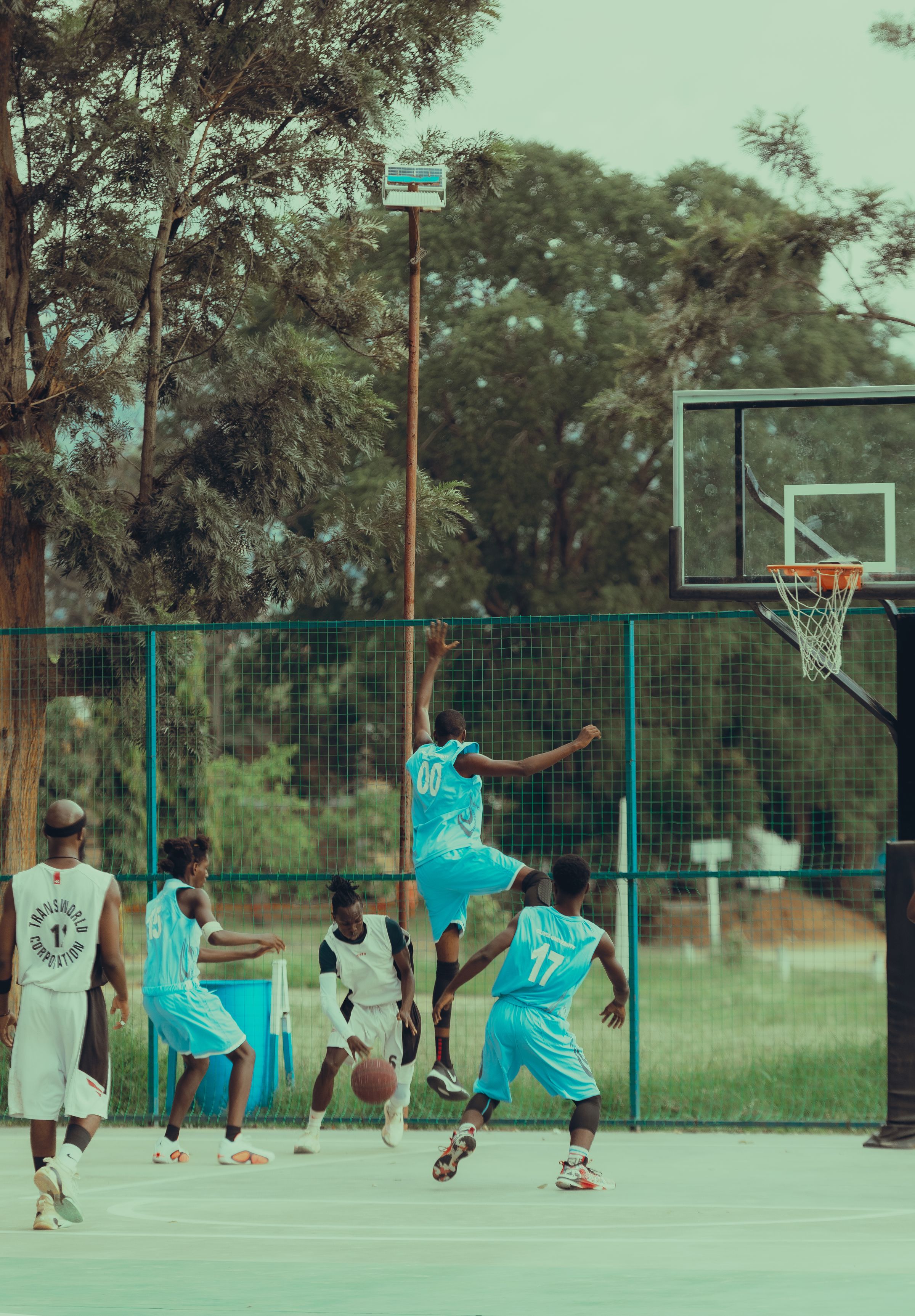 Teenagers playing basketball on an outdoor court