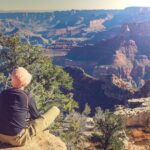 Person sitting on the rim of the Grand Canyon