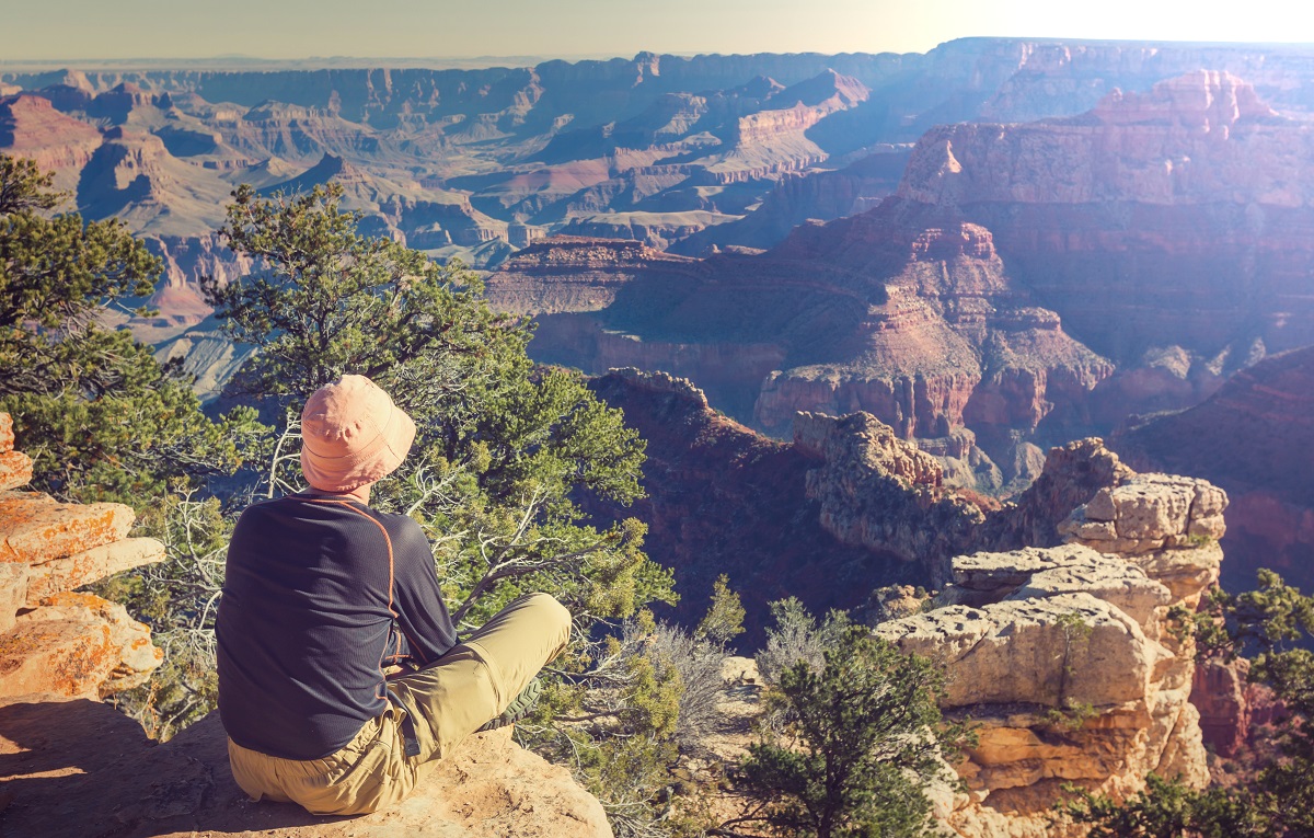 Person sitting on the rim of the Grand Canyon